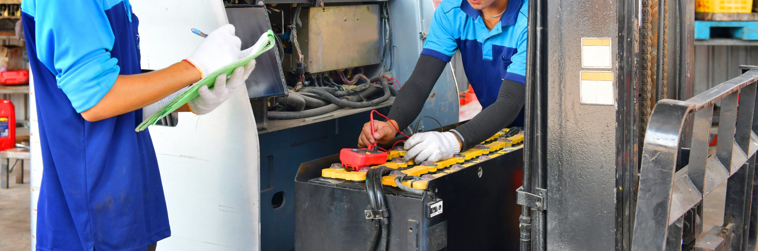 employees performing maintenance on forklift batteries